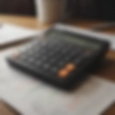 A close-up of a calculator and financial charts on a desk